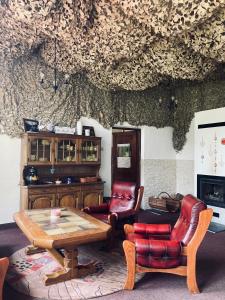 a living room with a table and leather chairs at Stara Szkoła in Krempna