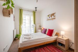 Un dormitorio con una cama con almohadas rojas y una ventana. en Russet Lodge Apartment, en Budapest