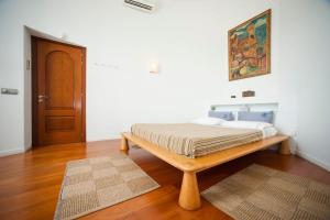 a bed in a room with a wooden table at Casa Rosa de los Vientos, al lado de la playa in Sant Josep de Sa Talaia +16 photos
