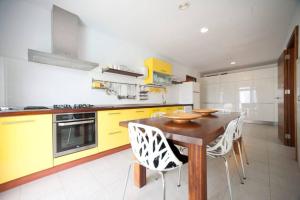 a kitchen with a wooden table and yellow cabinets at Casa Rosa de los Vientos, al lado de la playa in Sant Josep de Sa Talaia