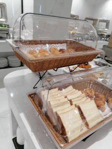 a counter with a tray of cheese and a basket of donuts at Paco Hotel Shenzhen Luohu Port in Shenzhen