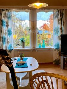 een woonkamer met een tafel en stoelen en een raam bij Flakaberget 15 in Lycksele