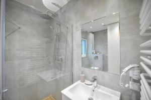 a bathroom with a sink and a shower and a mirror at Comfort Apartments Oświęcim in Oświęcim +126 photos