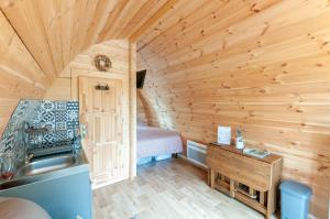 una cocina con fregadero en una cabaña de madera en Au pré des Alizés - insolite à la ferme des Alizés, en Vallon-sur-Gée