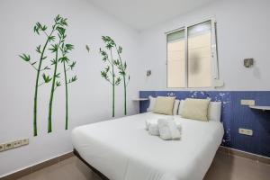 una camera da letto con un grande letto bianco con alberi sul muro di Charming Madrid Ferrocarril - Estancias Temporales a Madrid