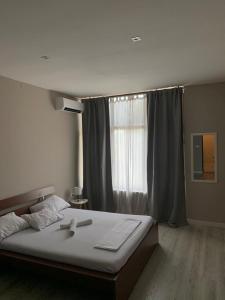 sypialnia z dużym łóżkiem i oknem w obiekcie Apartman Vukoja w mieście Grude