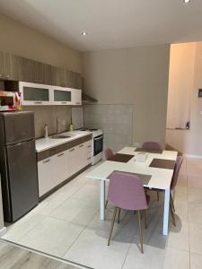 a kitchen with a table and purple chairs in it at Apartman Vukoja in Grude