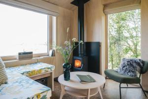 a room with a fireplace and a bed and a table at RewildThings Treehouses in Gloucester