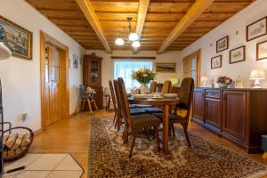 Un comedor con mesa y sillas en Villa Amalia, centrum Banska Stiavnica, parkovanie pre 2 auta, velka zahrada s krbom, cela Villa Amalia pre 16 osob alebo samostatne nezavisle prve podlazie Villa AMA pre 8 osob alebo samostatne nezavisle podkrovie Villa LIA pre 8 osob,prístup cez PIN-kód, en Banská Štiavnica
