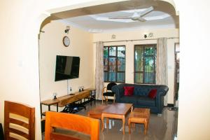 a living room with a couch and a table at Gorgeous 4 Bedroom House ideal for Families and Large Groups in Boma la Ngombe