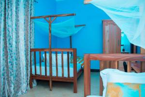 a bedroom with a crib and a blue wall at Gorgeous 4 Bedroom House ideal for Families and Large Groups in Boma la Ngombe