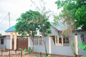 ein Haus mit einem Zaun davor in der Unterkunft Gorgeous 4 Bedroom House ideal for Families and Large Groups in Boma la Ngombe