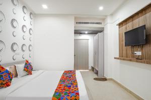 a bedroom with a bed and a flat screen tv at FabHotel Siddhi in Varanasi