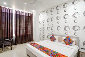 a bedroom with a bed and a wall with plates at FabExpress Samriddhi in Varanasi