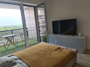 a bedroom with a flat screen tv and a large window at Waterfront City River view in Budapest