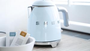 a white tea kettle sitting on a counter with a cup at Logement Overzee in Nes