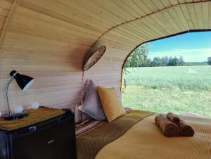 a bed in a small room with a view of a field at Under Canvas Bornholm in Østermarie