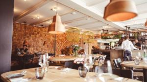 a restaurant with tables and people in the bar at Logement Overzee in Nes