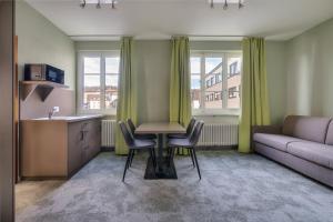 sala de estar con mesa, sillas y sofá en flexymotel Schönenwerd, en Schönenwerd