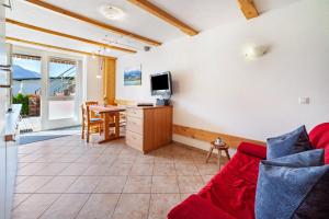 ein Wohnzimmer mit einem roten Sofa und einem Tisch in der Unterkunft Mühlanderhof Apt Klopairspitze in Reschen