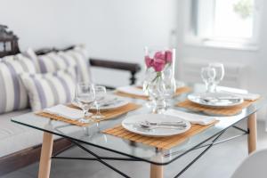 - une table en verre avec des assiettes et des verres à vin dans l'établissement Evmenia Luxury Cave Villa, à Oia 26 autres photos