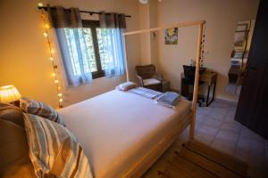 - une chambre avec un grand lit blanc et une fenêtre dans l'établissement Chiron Residence, à Mouresi