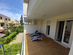 an open balcony with two chairs and a deck at Luxury home near the Beach private parking space in Alghero