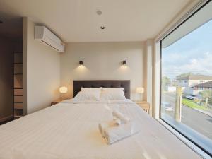 a bedroom with a large bed and a large window at Takapuna Brand new 3 Bedrooms in Auckland