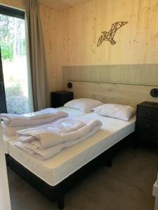 una camera con due letti e asciugamani bianchi di Luxe vakantielodge in Callantsoog aan zee a Callantsoog
