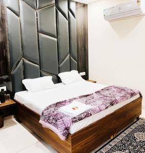 um quarto com uma cama com cabeceira de madeira em THE R MOTEL Phagwara City -- Full Privacy & Security -- Family,Corporate,Couples Favorite em Phagwāra