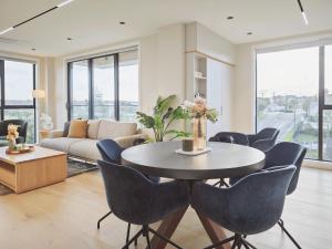 sala de estar con mesa y sillas en Takapuna Brand new 3 Bedrooms, en Auckland