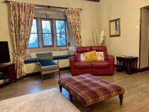 a living room with a red couch and a chair at Large Country Farmhouse in Waddington