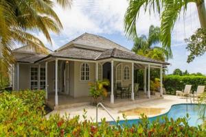 een villa met een zwembad en een huis bij Palm Ridge 2A Heaven Scent, Royal Westmoreland by Barbados Sothebys International Realty in Saint James