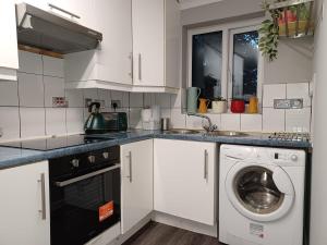 a white kitchen with a washing machine in it at Green Door-The Malting- Specious 1st Floor-One Bedroom Apartment -Fully Furnished-Quiet- Free Parking -Dunstable in Dunstable