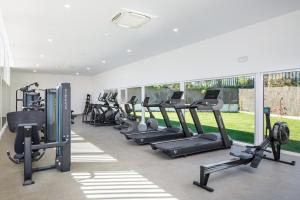 a gym with a row of treadmills and elliptical machines at AP Cabanas Beach & Nature - Adults Friendly in Cabanas de Tavira