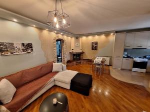 a living room with a brown couch and a kitchen at Home Spot Nafplio in Nafplio