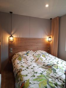 uma cama num quarto com duas luzes em SpaHuset em Sommelsdijk