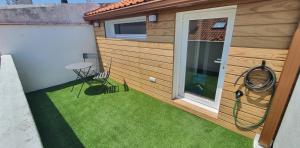 mały ogródek z małym patio i trawą w obiekcie Baiona w mieście Baiona