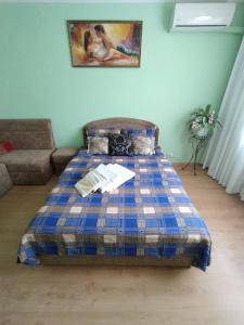 a bed in a living room with a plaid blanket at Центр города, чистые, аккуратные с хорошим ремонтом квартиры посуточно in Poltava