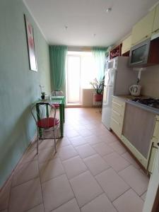 a kitchen with a table and a refrigerator and a chair at Центр города, чистые, аккуратные с хорошим ремонтом квартиры посуточно in Poltava