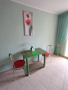 a green table and two chairs in a room at Центр города, чистые, аккуратные с хорошим ремонтом квартиры посуточно in Poltava