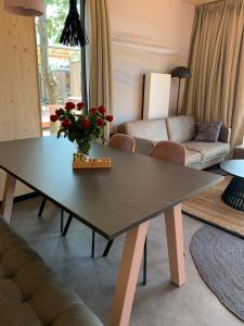 un soggiorno con tavolo e divano di Luxe vakantielodge in Callantsoog aan zee a Callantsoog