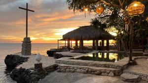 a church with a cross on the beach at sunset at Santiago Project by Aluminak in Santiago