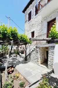 - un bâtiment en pierre avec un escalier à côté d'une maison dans l'établissement Αρχοντικό Θεανώ 1 Archontiko Theano 1, à Agios Lavrentios