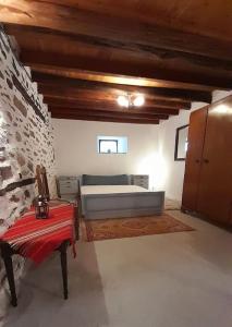 - une chambre avec un lit et un banc dans l'établissement Αρχοντικό Θεανώ 1 Archontiko Theano 1, à Agios Lavrentios