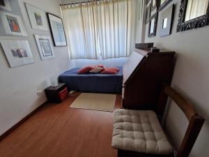 um pequeno quarto com uma cama e uma janela em Casa da catarina em Linda-a-Velha
