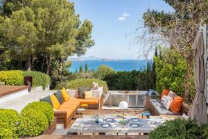 an outdoor patio with furniture and a view of the ocean at Villa Verde Costa Brava - BY EMERALD STAY in Begur