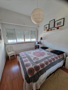 a bedroom with a bed with a quilt on it at Casa da catarina in Linda-a-Velha