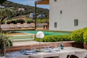 a table with glasses and plates on it next to a pool at Villa Verde Costa Brava - BY EMERALD STAY in Begur