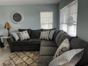uma sala de estar com um sofá cinzento num quarto em Cooper's Lighthouse Home em Myrtle Beach